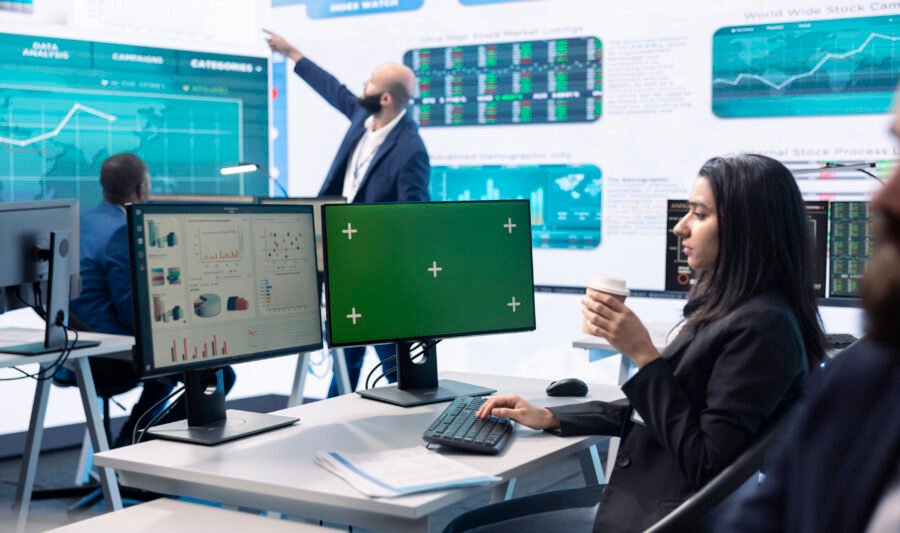 Businesswoman analyzing infographics next to green screen in enterprise headquarters, studying annual sales reports to check customer retention for organizational development.
