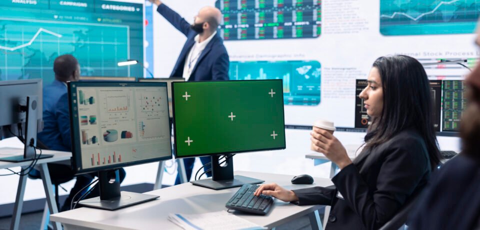 Businesswoman analyzing infographics next to green screen in enterprise headquarters, studying annual sales reports to check customer retention for organizational development.